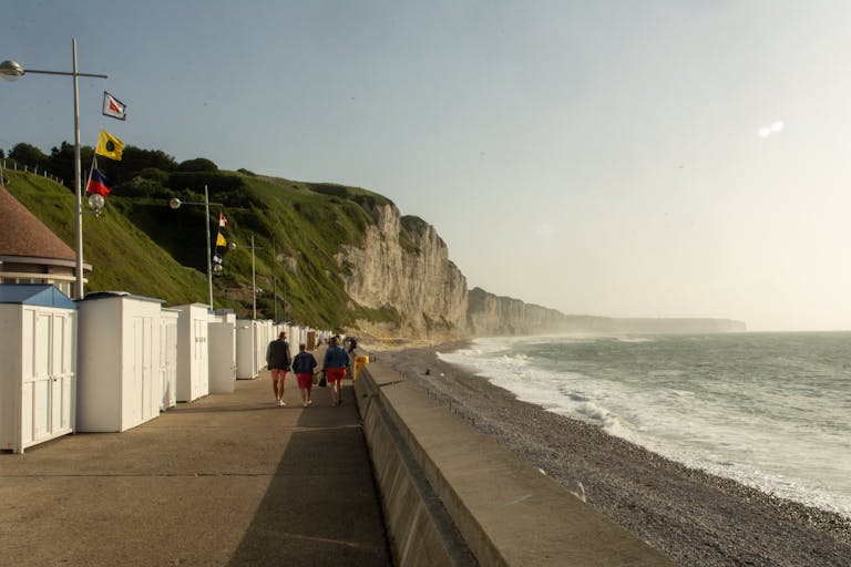 Explore the scenic beachfront of Fécamp, Normandy with iconic cliffs and promenade view.