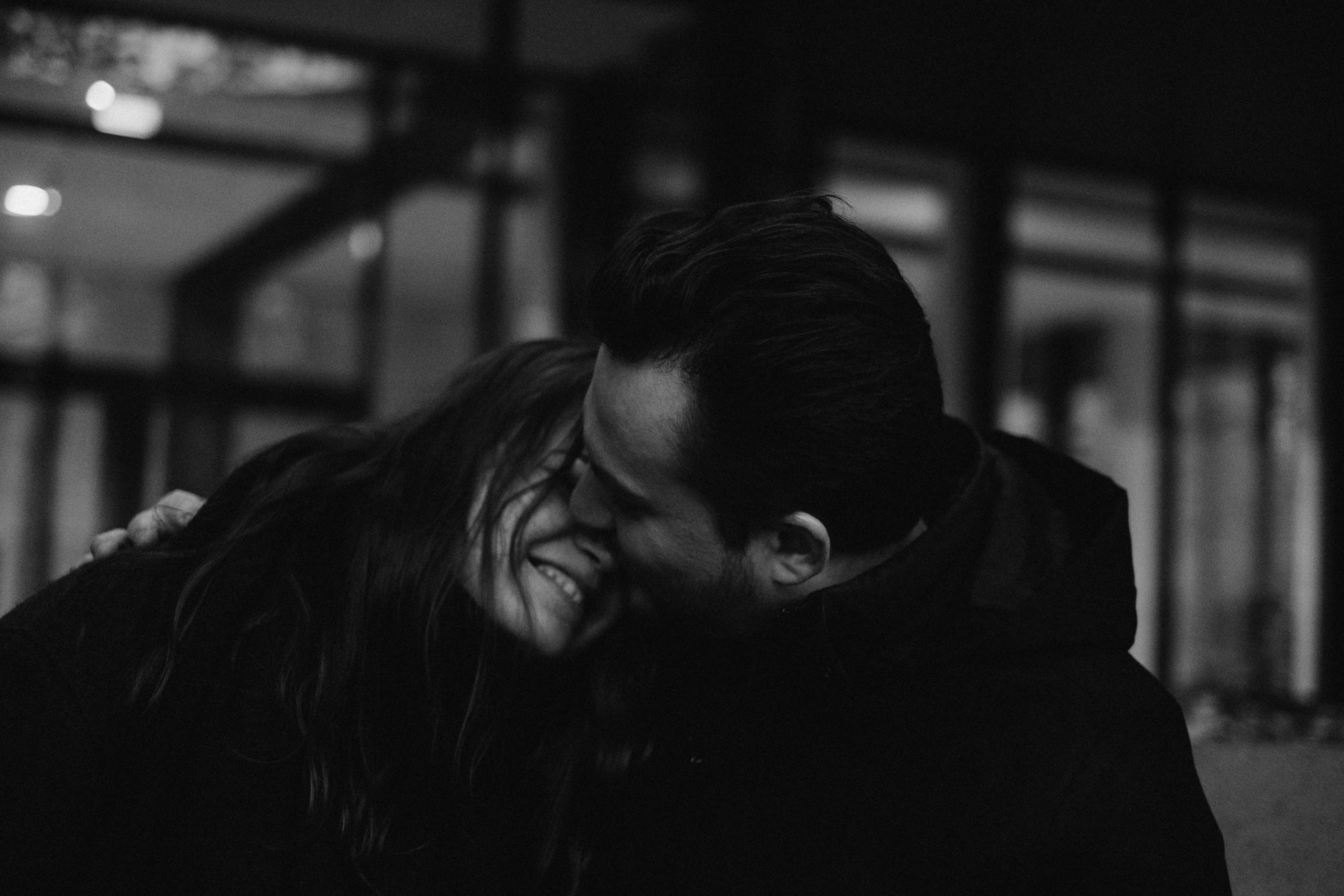 Intimate black and white portrait of a couple sharing a tender moment indoors.