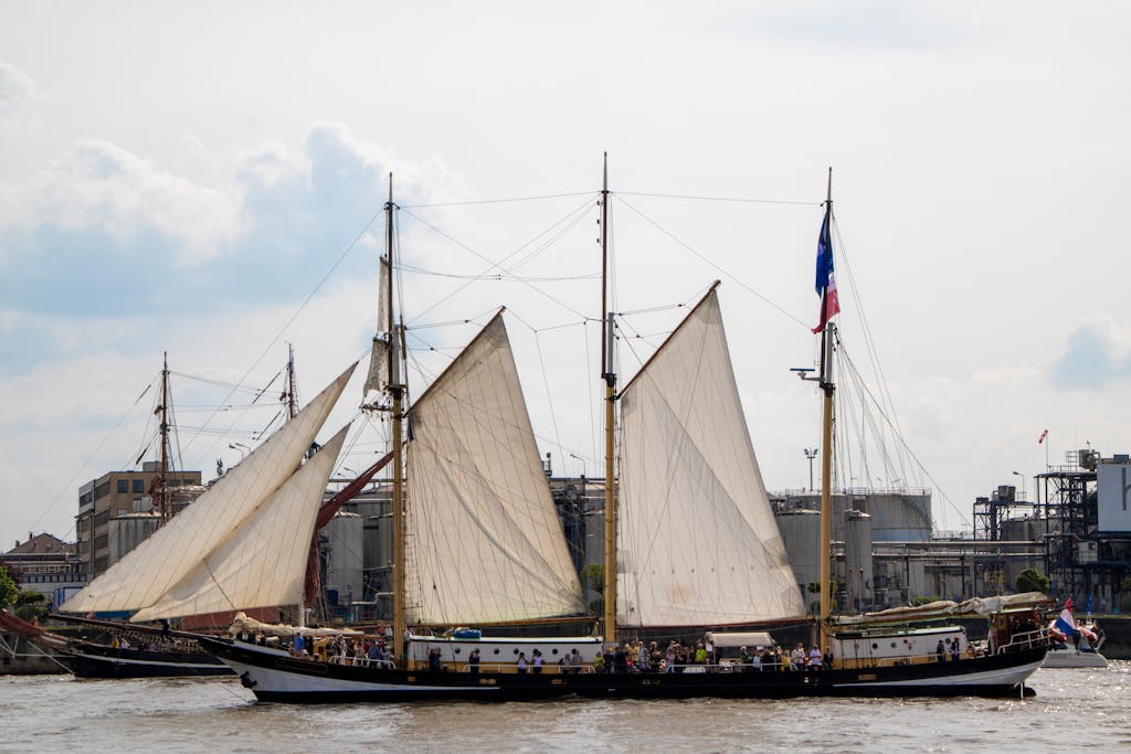 A majestic sailing ship in Hamburg's vibrant harbor, Germany, under a serene sky.