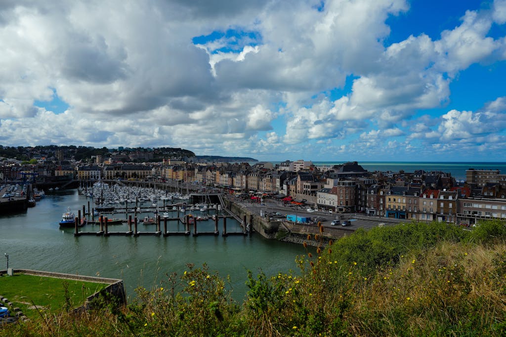 Breathtaking view of a vibrant harbor town with docks and sailboats under a bright sky.