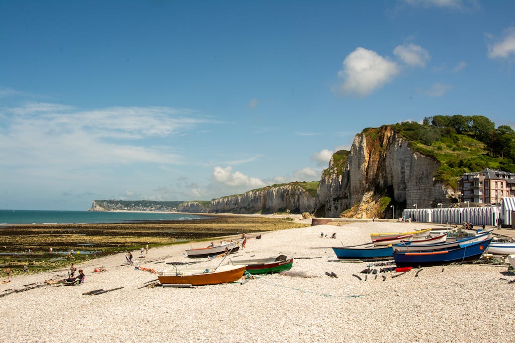 Scenic view of Yport beach with fishing boats and cliffs in Normandy, France.