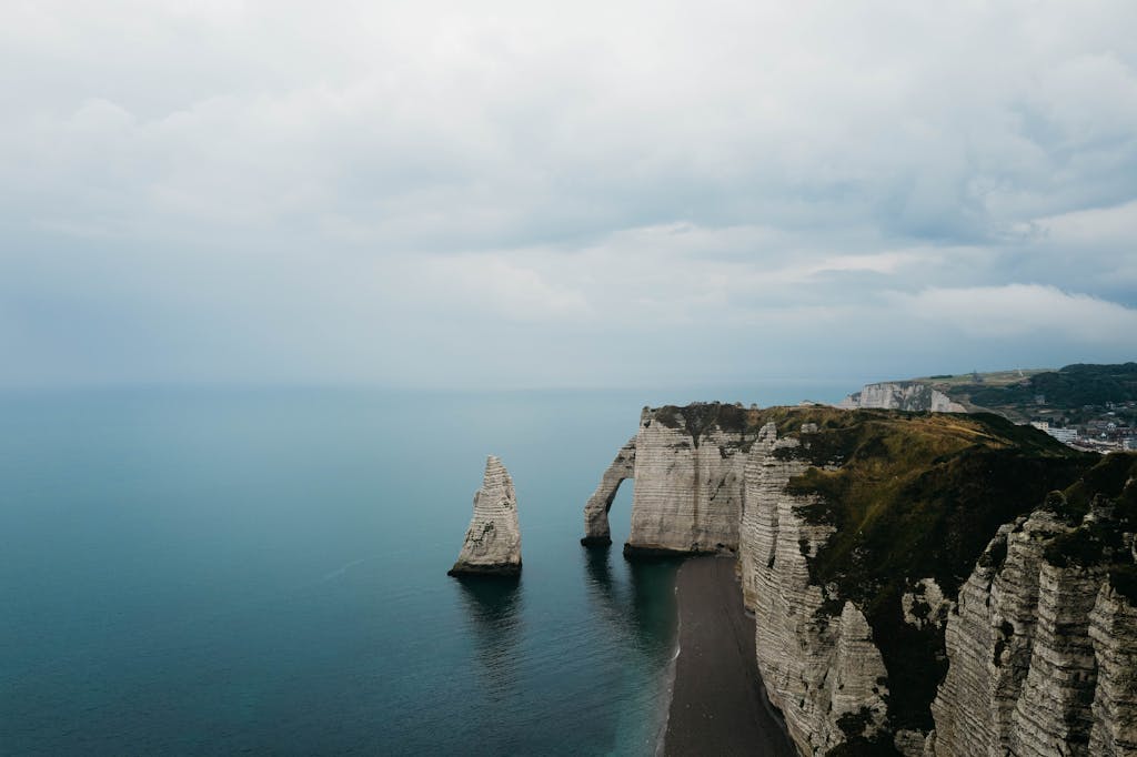Stunning aerial view of the iconic limestone cliffs and natural arches at Étretat, Normandy.